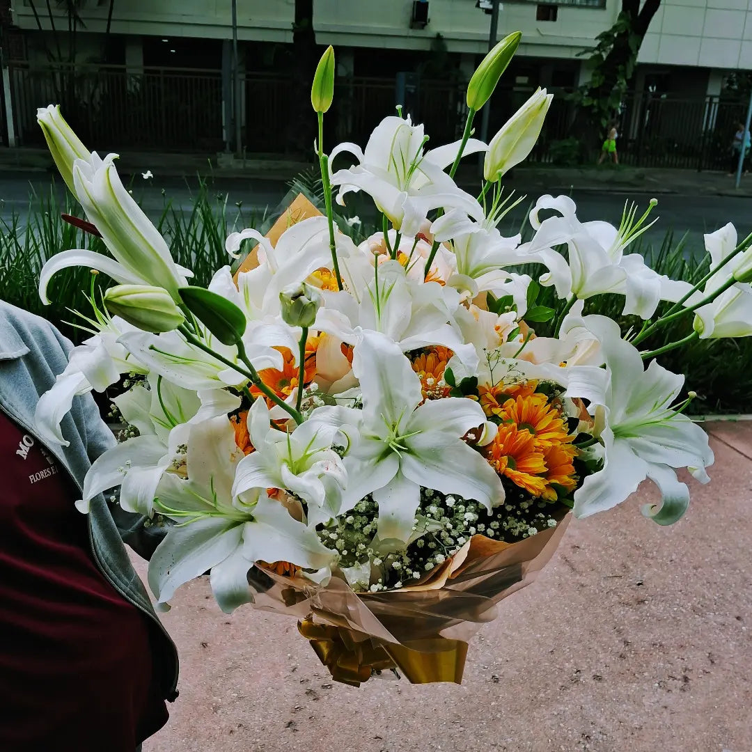 Buquê de lírios brancos com margaridas laranjas